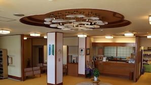 Un vestíbulo de hotel con mostrador de recepción, zona de estar y una original disposición circular de asientos.
