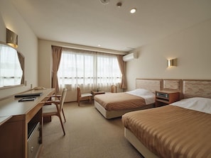 A hotel room with a desk, two beds, a chair, and a large window with curtains. - Kutsuroginoyado Manseiro (Nachikatsuura)