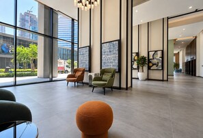 Eine geräumige Lobby mit großen Fenstern, modernen Sesseln und einem minimalistischen Design.
