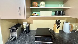 Een keuken met een koffiezetapparaat, broodrooster en een messenblok op het aanrecht.