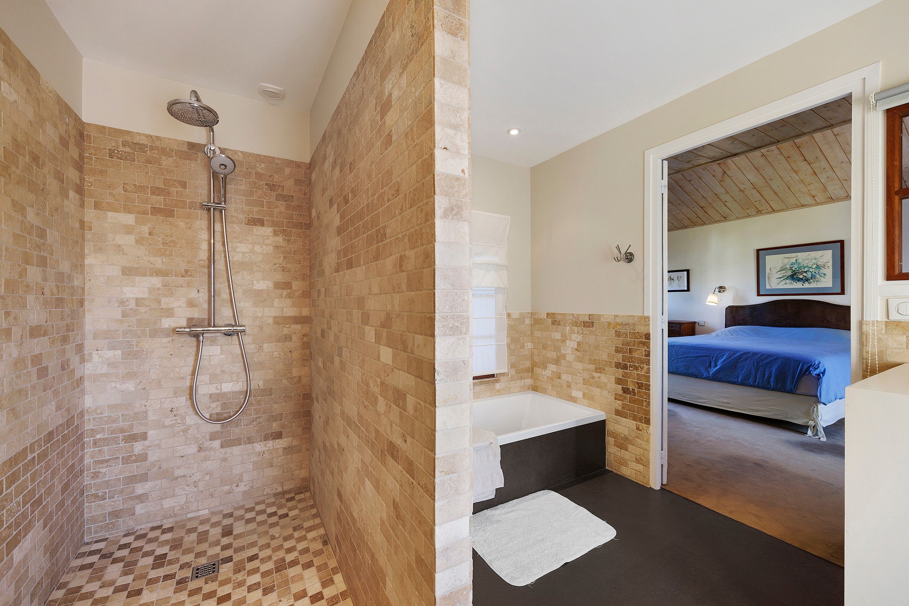 Une salle de bain avec une douche, une baignoire et des toilettes.