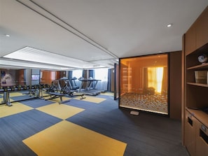 A gym with exercise equipment, a mirrored wall, and a large window. - Hampton Inn Lianyungang (Lianyungang)