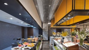 Disposição de buffet com diversos alimentos e um balcão de mármore.