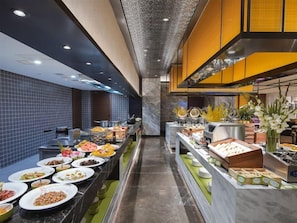 A buffet setup with various food items and a marble counter. - Hampton Inn Lianyungang (Lianyungang)