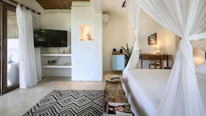 A bedroom with a bed, a television, a desk, and a computer. - Hotel Fazenda Cala and Divino (Porto Seguro)