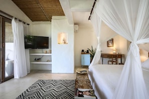 A bedroom with a bed, a television, a desk, and a computer. - Hotel Fazenda Cala and Divino (Porto Seguro)