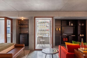 A modern room with a bed, a seating area, a wardrobe, and a view through a window. - S Bento Residences Porto sao Bento (Porto)