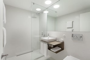 A modern bathroom with a glass shower enclosure, a white sink, and a mirror. - S Bento Residences Porto sao Bento (Porto)