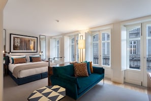 A modern hotel room with a bed, a sofa, a table, and large windows. - S Bento Residences Porto sao Bento (Porto)