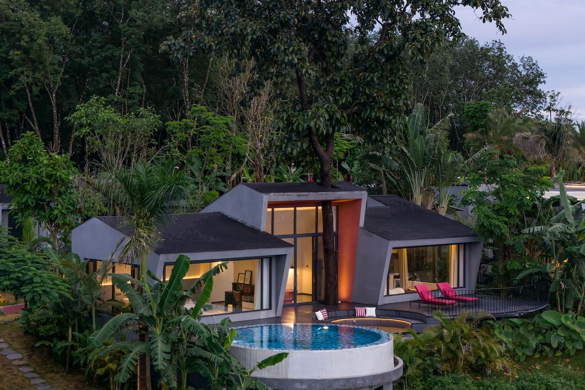 Een modern huis met een zwembad, omringd door weelderige begroeiing.