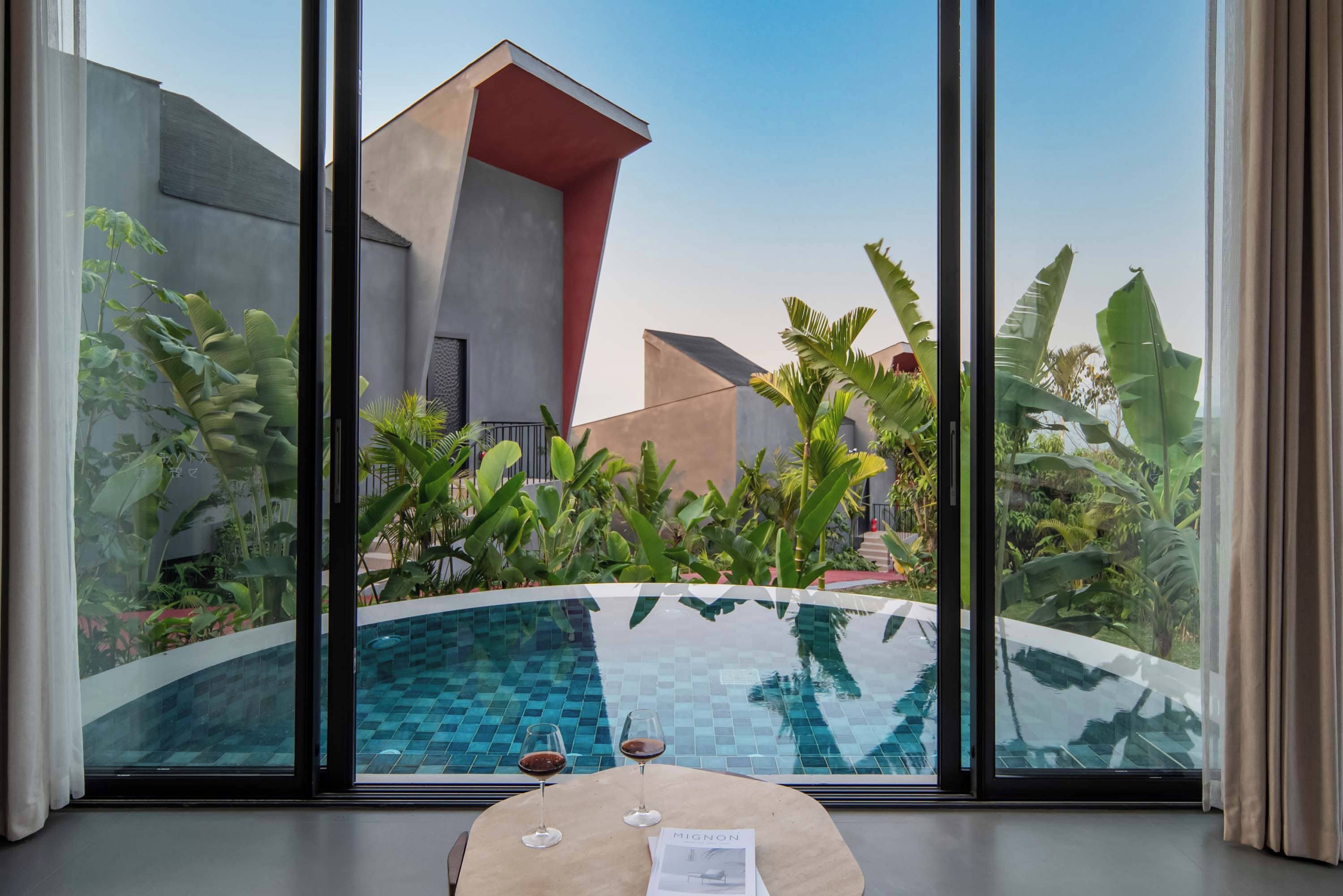 A modern pool area with a clear view of the surrounding architecture and lush greenery.