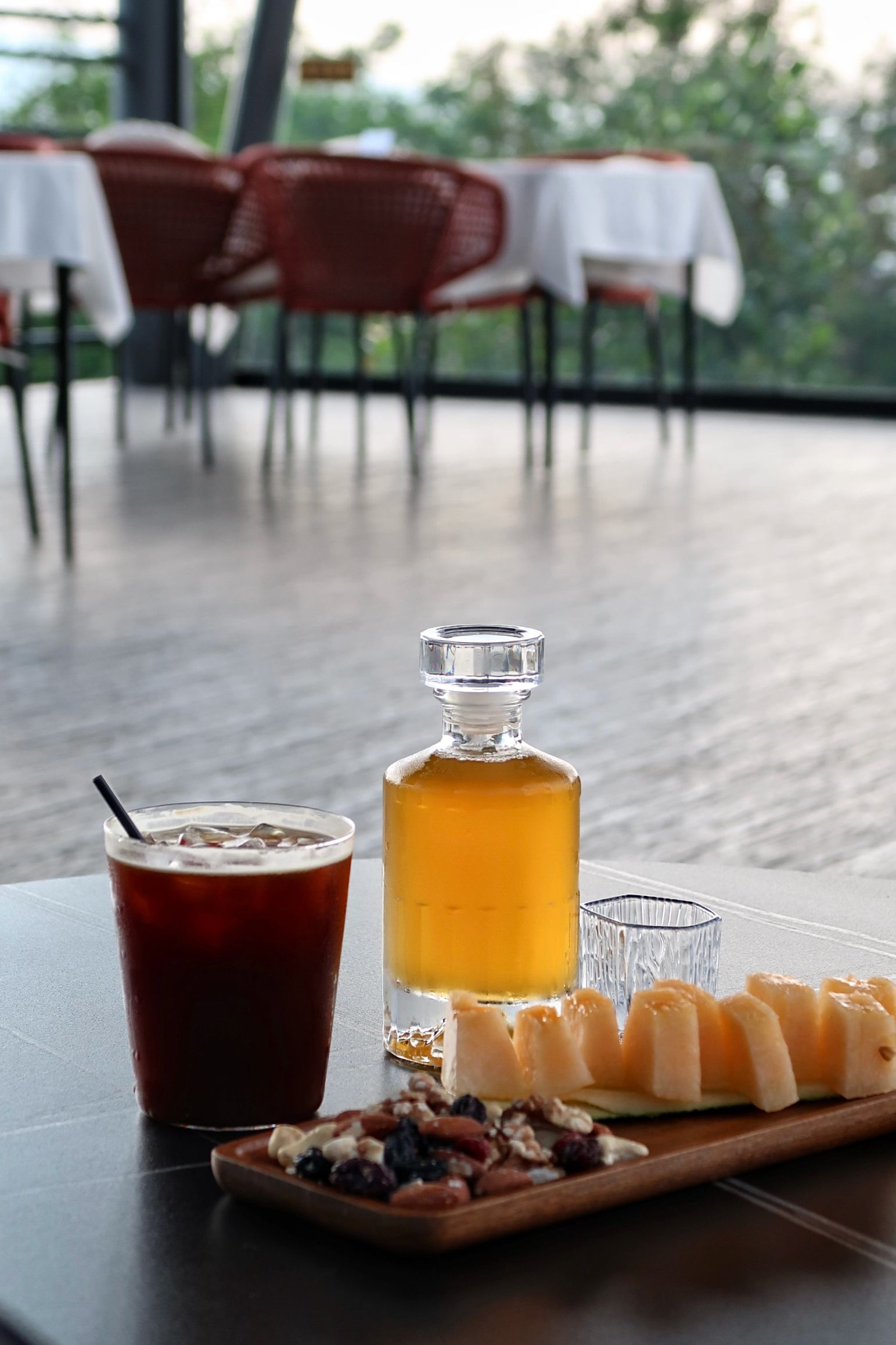 A table with a beverage, a bottle, and a plate of food.