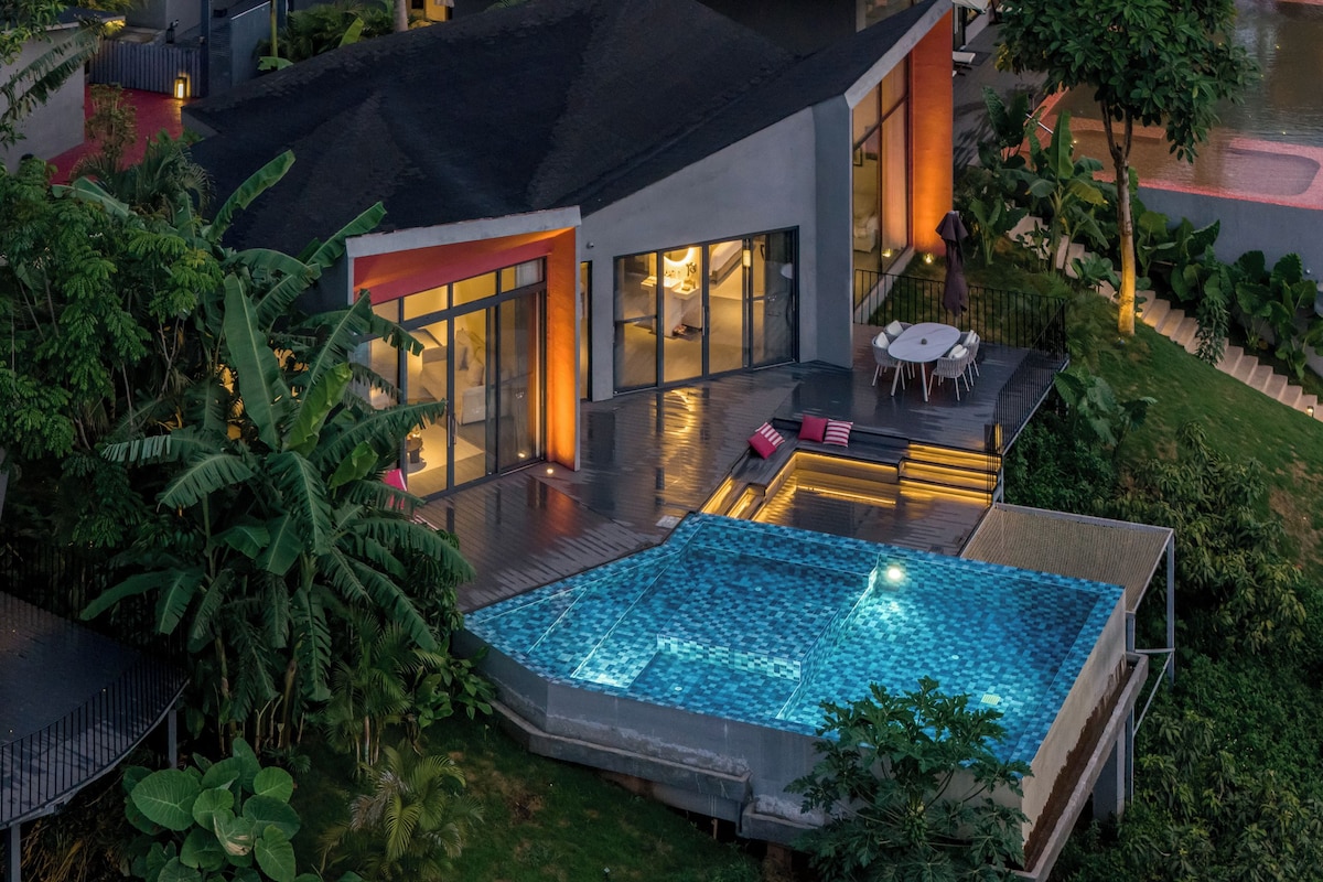 Een modern huis met een zwembad, tuinmeubilair en weelderige beplanting.
