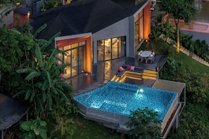A modern house with a swimming pool, outdoor furniture, and lush greenery. - XiyeSeclusionResortHotel (Xishuangbanna Dai)