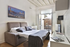 Un dormitorio moderno con una cama, un escritorio y una pintura de un paisaje urbano.