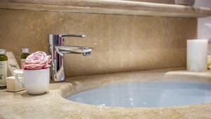 A bathroom with a sink, a mirror, and toiletries. - Arno Apartment B (Florence)