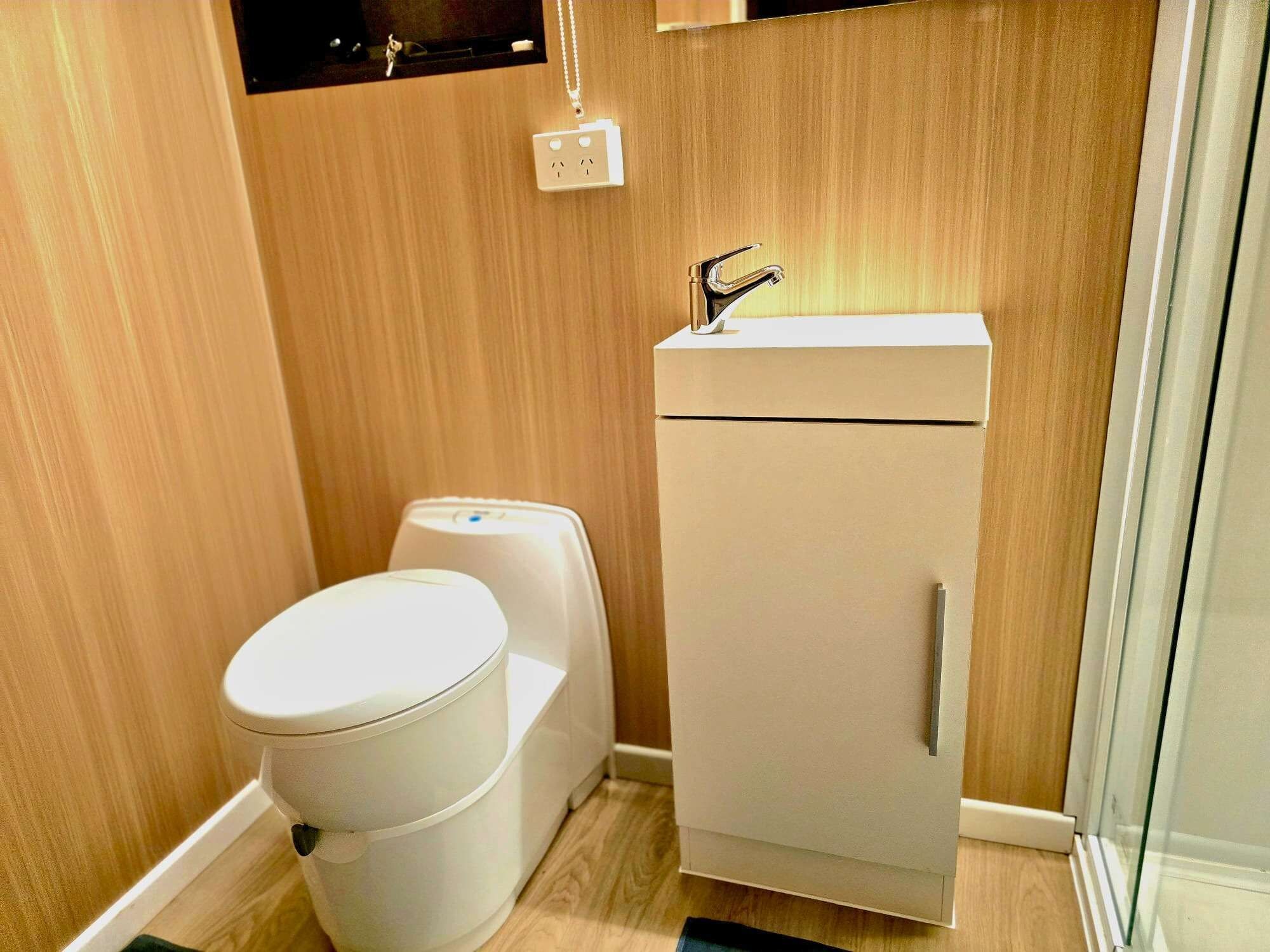 A compact bathroom with a toilet, a sink, and a cabinet.