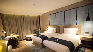 A hotel room with two beds, a small table, a chair, and a large window with curtains. - Echarm Hotel Xiantao Stadium (Beijing)