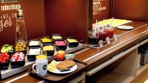 A buffet with various food options including fruits, vegetables, and beverages. - Ibis Budget Flensburg City (Flensburg)