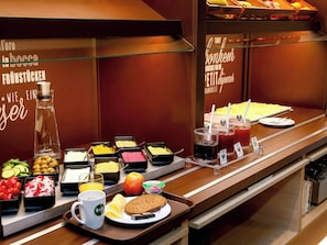 A buffet with various food options including fruits, vegetables, and beverages. - Ibis Budget Flensburg City (Flensburg)