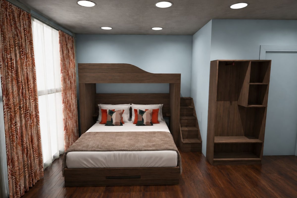 Une chambre avec un lit superposé, une armoire en bois et un escalier.