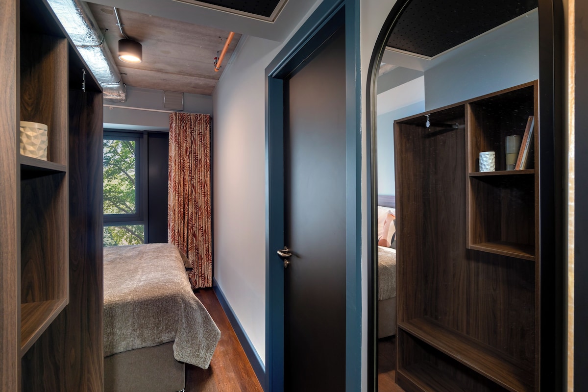 Une pièce comprenant un lit, une armoire et une porte donnant sur une autre pièce.