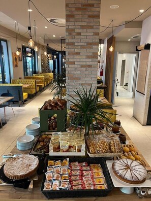 Un buffet allestito con diversi cibi e un pilastro in mattoni al centro.