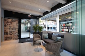 Un interno moderno con un'area salotto, l'ingresso di un caffè e vista sulla strada.
