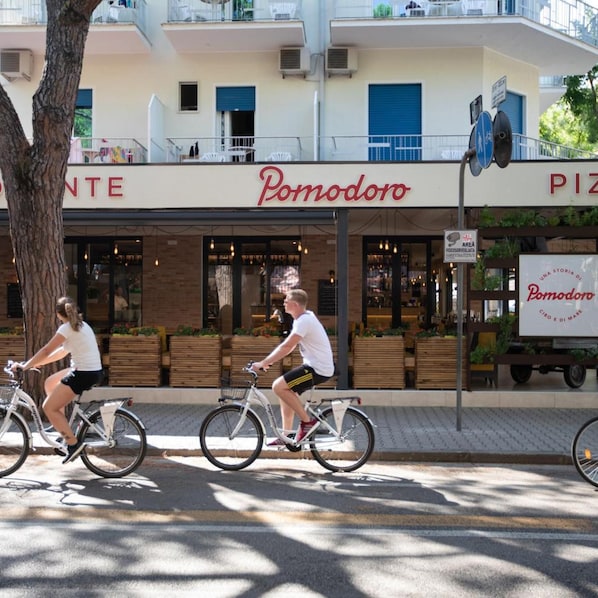 Una vista di strada con un ristorante chiamato 'Pormodoro' e un furgone per consegne parcheggiato davanti.