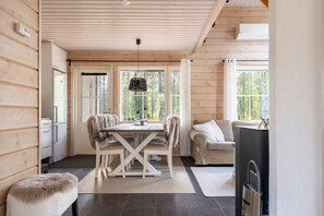 A cabin interior with a dining table, chairs, a sofa, and a television. - Kaakkoishovi by Aavalevi (Levi)