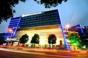 En moderne hotelbygning med flere etager og et tydeligt skilt.
