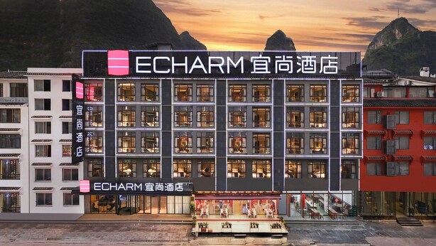 A multi-story building with a prominent sign for 'ECHARM' hotel. - Echarm Hotel (Guilin)