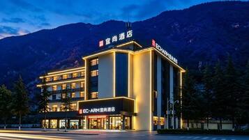A hotel with a modern design, featuring multiple floors and a prominent sign.