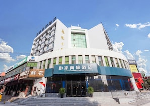 A hotel with a modern facade, multiple floors, and a prominent entrance with steps leading up to it. - Homeinn Selected (Weifang)