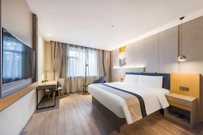 A hotel room with a bed, bedside table, TV, and a desk with a chair. - Homeinn Selected (Weifang)