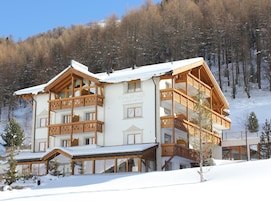 Un hotel de varios pisos con balcones de madera y un techo cubierto de nieve.