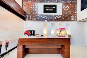 Mostrador de recepción con un cartel que indica servicio de la empresa, una computadora y un acuario.