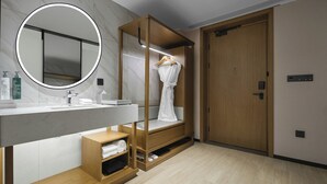 Un baño moderno con tocador, espejo y mueble de almacenamiento de madera.
