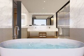 A modern bathroom with a large bathtub, a mirror above the sink, and a view of the city through the window.