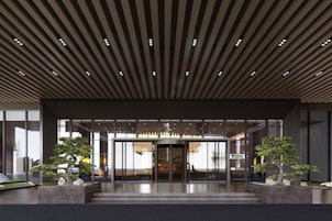 Una entrada moderna a un edificio con techo inclinado y puertas de vidrio.