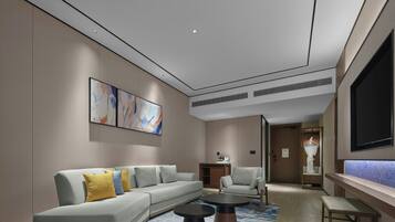 A modern living room with a sectional sofa, two round coffee tables, a flat-screen TV, and abstract wall art.