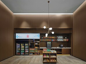A modern retail space with a vending machine, shelves stocked with snacks, and a checkout counter.