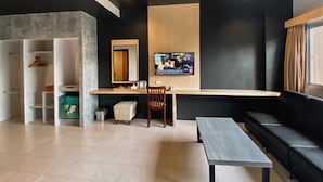 Una sala moderna con un sofá, un televisor, una mesa de madera y un banco.
