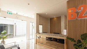 A reception area with a marble counter, a 'Check In' sign, and a 'No Smoking' sign. - B2 Map Ta Phut Boutique & Budget Hotel (Rayong)