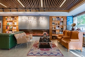 A modern lounge area with leather sofas, a fireplace, and bookshelves. - James Joyce Beijing Chongwenmen Tiantan Qiaowan Subway Station (Beijing)