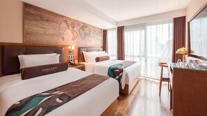 A hotel room with two beds, a desk, a map on the wall, and a view of the city. - James Joyce Beijing Chongwenmen Tiantan Qiaowan Subway Station (Beijing)