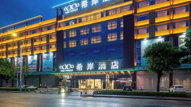 Un hôtel doté d’une façade moderne, de plusieurs étages et d’une enseigne lumineuse.