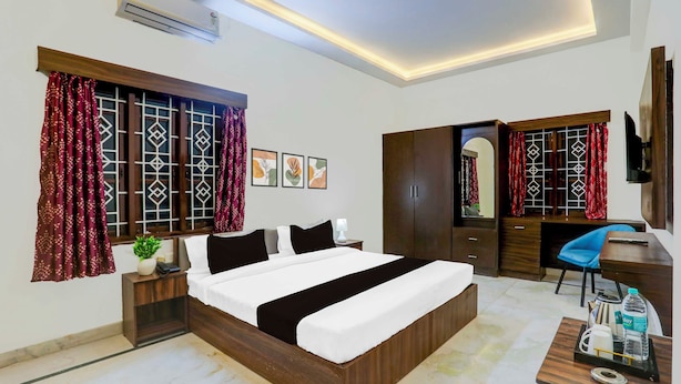 Une chambre d’hôtel avec un lit, un bureau, une armoire et un téléviseur.