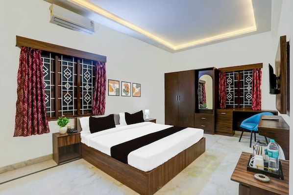 Une chambre d’hôtel avec un lit, un bureau, une armoire et un téléviseur.