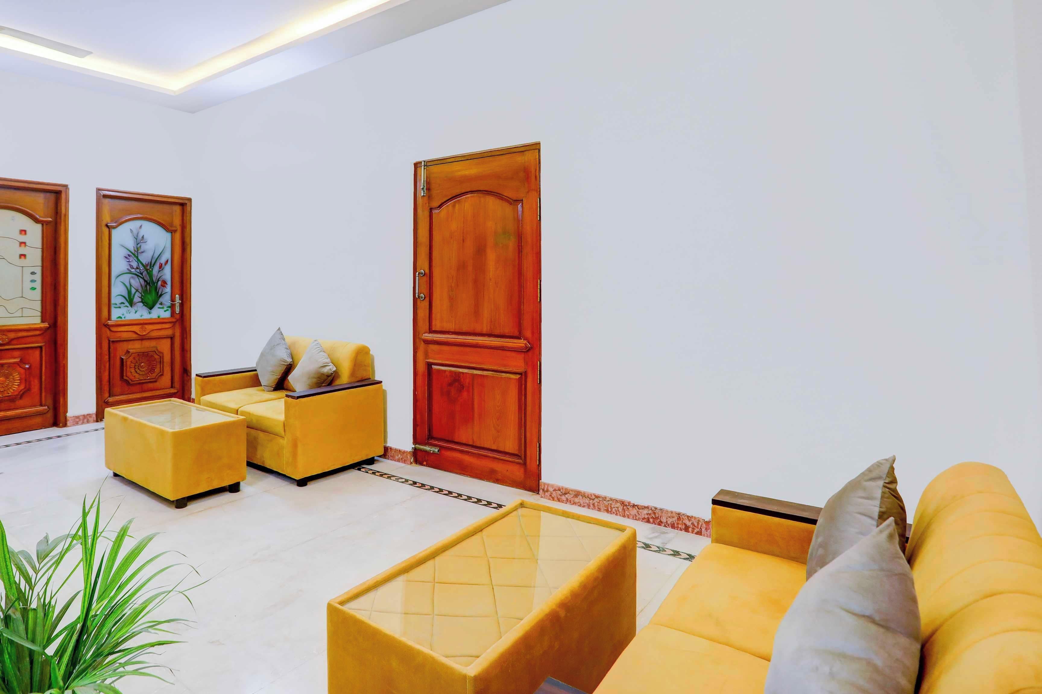 Een woonkamer met een bank, een salontafel en een deur met decoratief paneel.